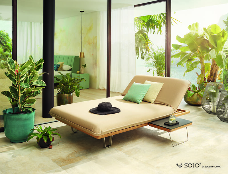 Helle Outdoor-Lounge mit Liege und Pflanzen