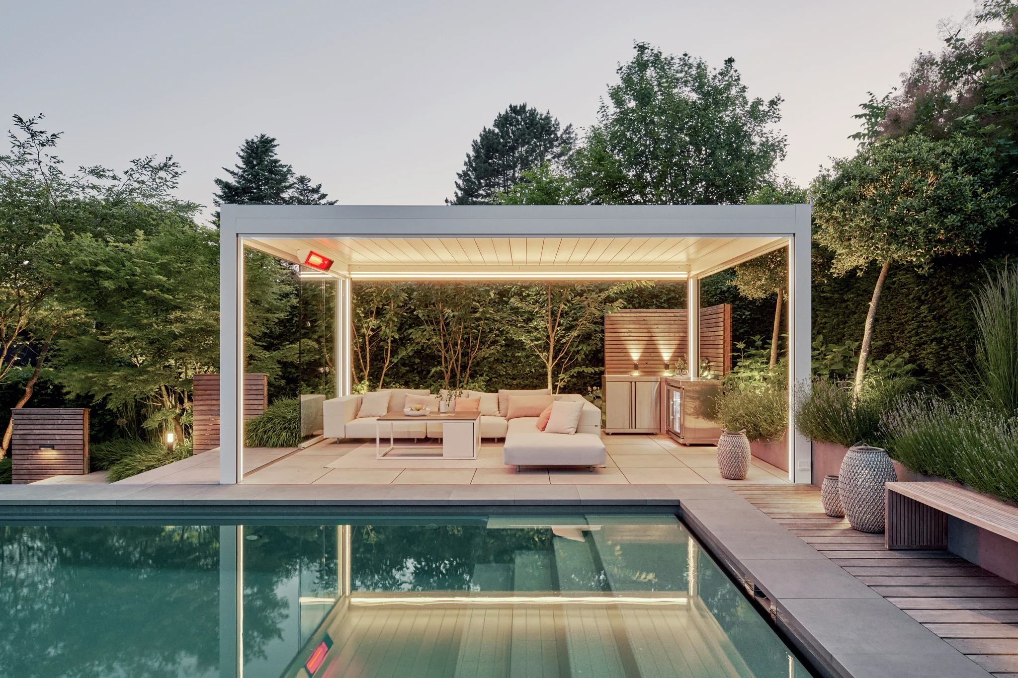 Lounge am Pool mit Lamellendach und stimmungsvoller Beleuchtung